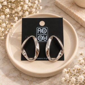 RO Accessories Sculptural Oval ασημί statement σκουλαρίκια με μεγάλο ακανόνιστο οβάλ σχέδιο, ανοιχτό κέντρο και γυαλιστερές μεταλλικές καμπύλες.