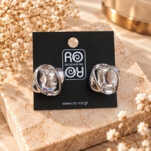 RO Accessories Crystal Embrace ασημί σκουλαρίκια με μεγάλη διάφανη ορθογώνια πέτρα και γυαλιστερές μεταλλικές καμπύλες.